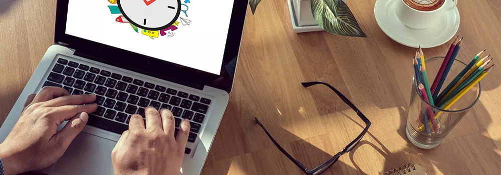 HR manager using laptop with time management clock graphic, illustrating best clocking in systems software