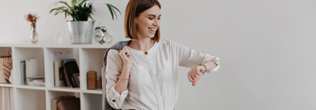 Smiling employee checking her watch to illustrate the right to disconnect and work-life balance in the UK.