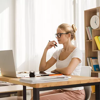 Femme travaillant sur un ordinateur portable à domicile, en télétravail